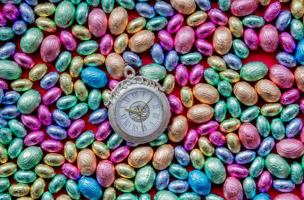 väri Suklaa pääsiäismunat ja herätyskello sitä
 - Valokuva, kuva