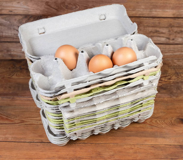 Stack of open pulp egg cartons with several chicken eggs - Photo, Image