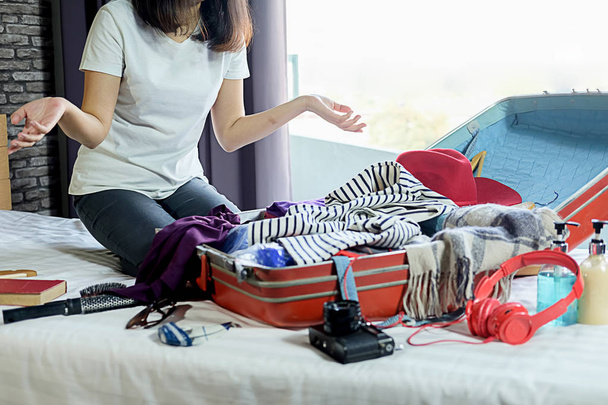 La gente empacó la maleta con accesorios de viaje en la cama. Vacaciones
  - Foto, imagen
