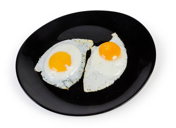 Two fried eggs prepared sunny side up on black dish - Photo, Image