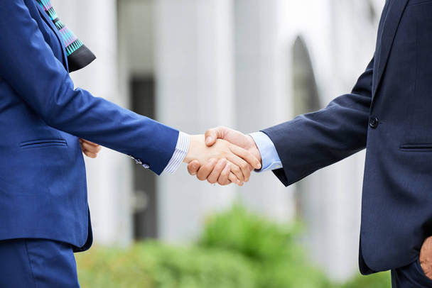 Crop side view of elegant man and woman shaking hands in agreement on street - Foto, Imagem
