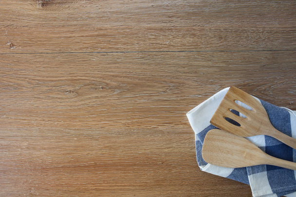 Wooden kitchen utensils and linen kitchen towels on light wood tabletop - Foto, Imagem