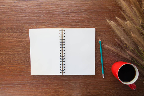 notebook, pencil, grass on wooden table and cup of coffee on woo - Foto, immagini