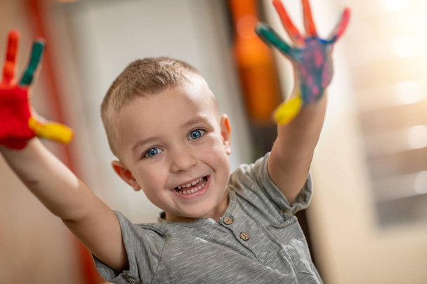 Éducation créative.Petit garçon avec les mains peintes en peinture colorée
. - Photo, image