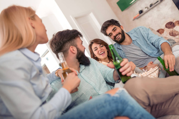 Przyjaźń, wypoczynek i osób znajomych koncepcja szczęśliwy pić piwo i oglądać mecz piłki nożnej w telewizji w domu. - Zdjęcie, obraz