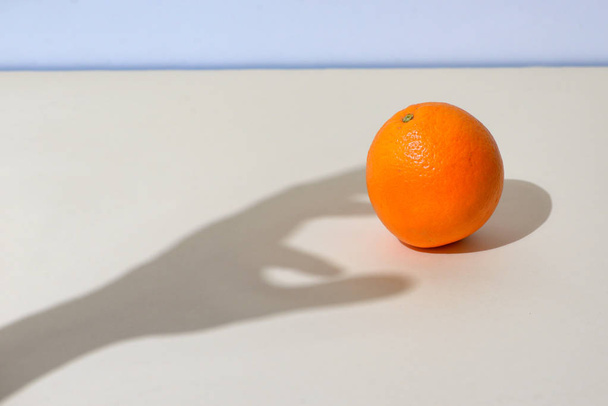 Mano masculina recoge una naranja
 - Foto, Imagen
