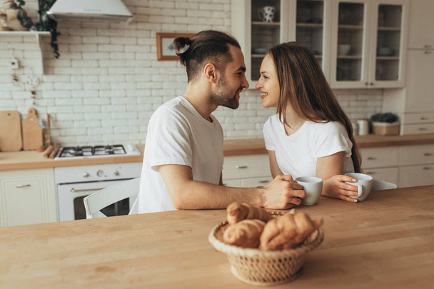Beautiful loving couple kissing in kitchen - Foto, afbeelding