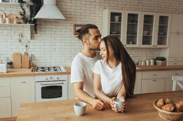 Beautiful loving couple kissing in kitchen - Fotoğraf, Görsel