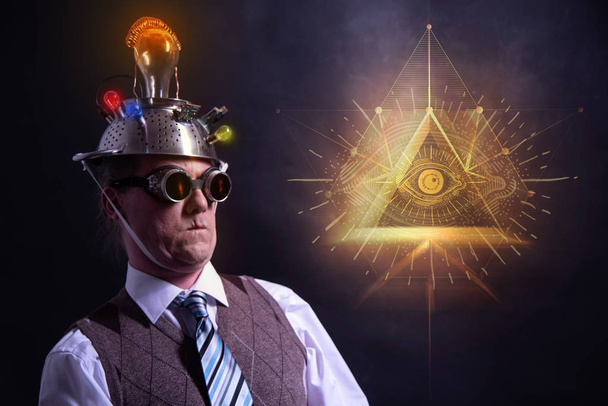 angustiado creyente conspiración buscando en traje con cabeza de papel de aluminio y signo illuminati
 - Foto, imagen