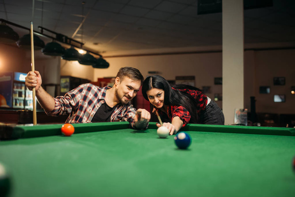 Aile çift Bilardo odasında oynuyor. Erkek ve kadın Hobiler, spor bar, erkek oyuncu atış amaçlayan Amerikan pool oyunu - Fotoğraf, Görsel