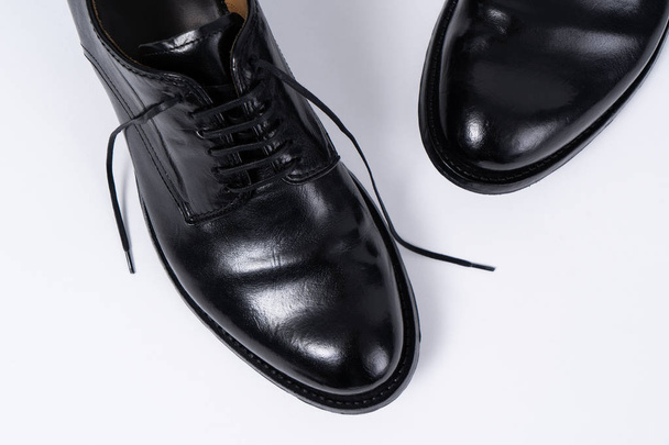 Two classical black leather shoes on white background. Closeup view from above. - Photo, Image