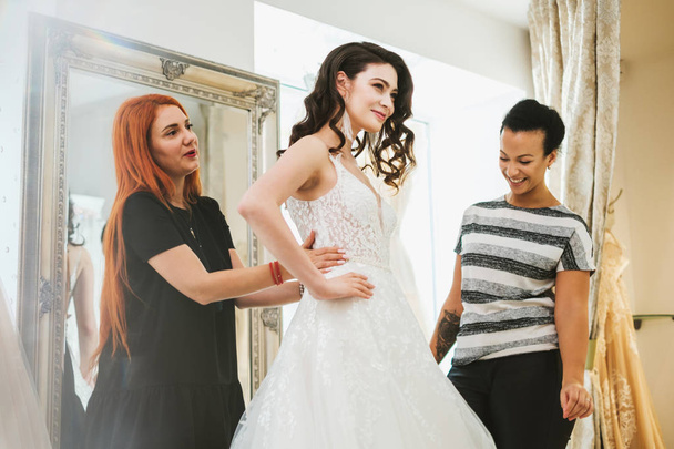 Beautifu novia elegir vestido de novia en un salón de bodas
 - Foto, imagen