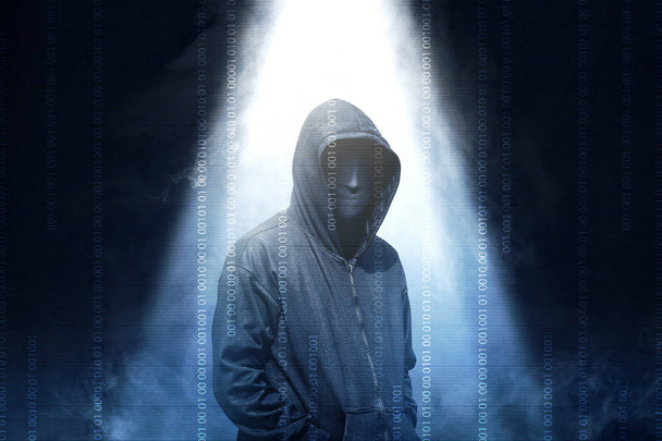 Hacker in black hoodie standing with smoke and light from the to - Foto, afbeelding