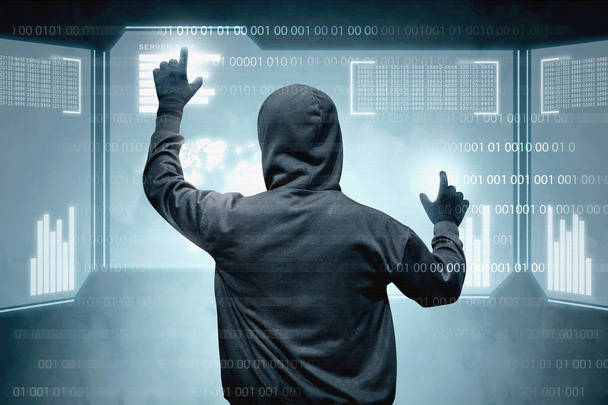 Rear view of hacker in black hoodie touching virtual screen - Foto, Imagem