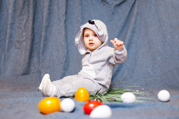baby in   hare jumpsuit and easter eggs. - Photo, Image