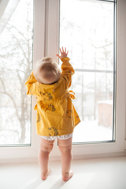 Malé děťátko v nebezpečné pozici u okna.  - Fotografie, Obrázek