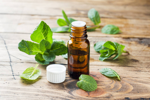 Essential aroma oil with peppermint on wooden background. Selective focus, copy space. - Foto, immagini