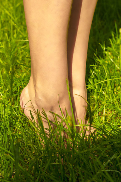 Nainen paljain jaloin vihreä nuori ruoho nurmikon
 - Valokuva, kuva