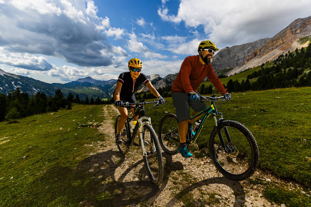 ドロミテの山々 でバイクに乗ってサイクリング男女と - 写真・画像