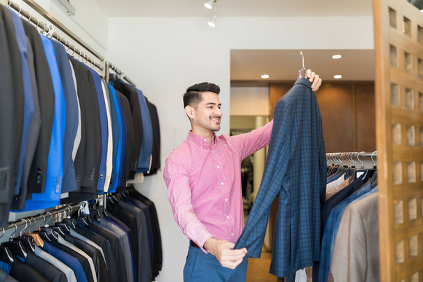 S úsměvem atraktivní muž nákup obleku na nájemné od obchod s oblečením - Fotografie, Obrázek