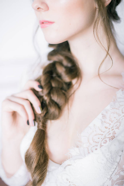 Young cute bride with beautiful hair in the morning at home in white lace negligee - Foto, Imagem