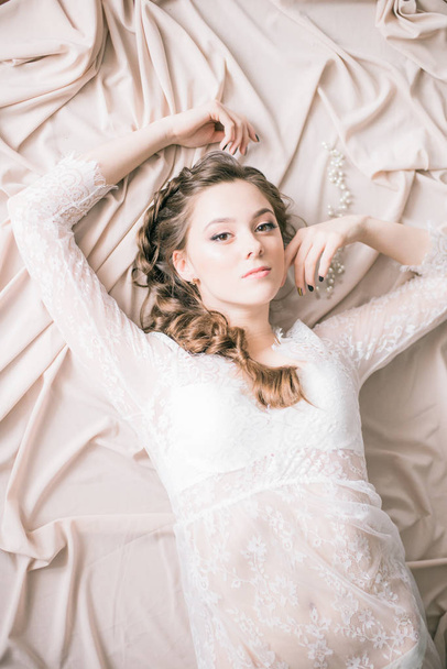 Young cute bride with beautiful hairdo morning at home in white lace negligee - Fotoğraf, Görsel