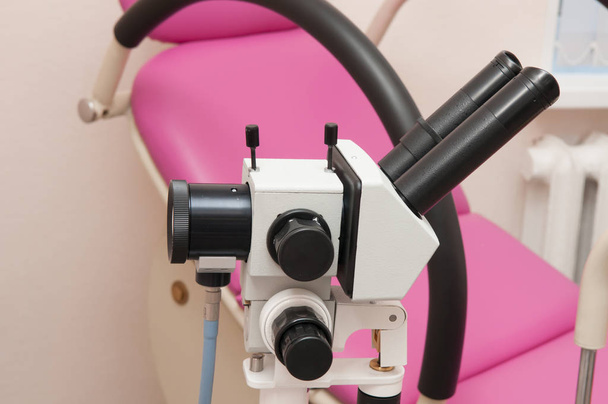 El colposcopio en el fondo de la silla ginecológica
 - Foto, imagen