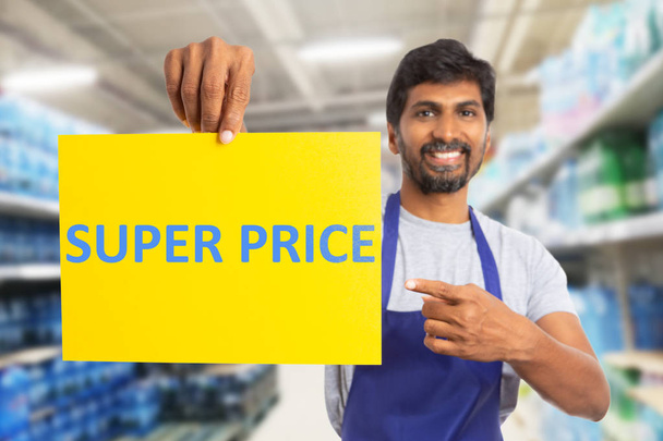 Supermarket worker pointing at super price pape - Photo, Image