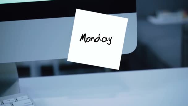 Monday. Days of the week. The inscription on the sticker on the monitor. Message. Motivation. Reminder. Handwritten text written with a marker. Color sticker. A message for an employee, a colleague - Footage, Video