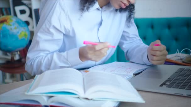 Close up african amercian female student making marks in textbooks while preparing for exam - Materiał filmowy, wideo
