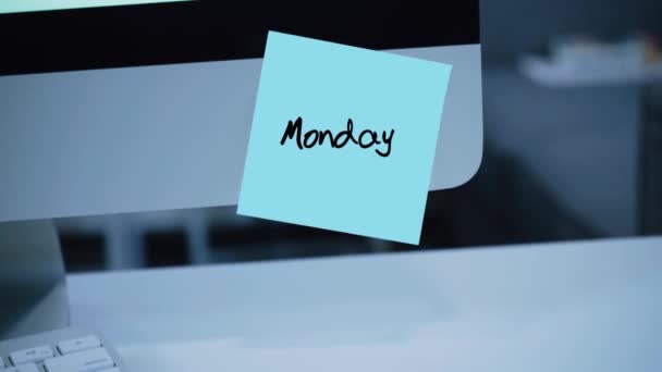 Monday. Days of the week. The inscription on the sticker on the monitor. Message. Motivation. Reminder. Handwritten text written with a marker. Color sticker. A message for an employee, a colleague - Footage, Video