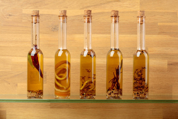 Bottles of olive oil with herbs and spices. - Photo, image