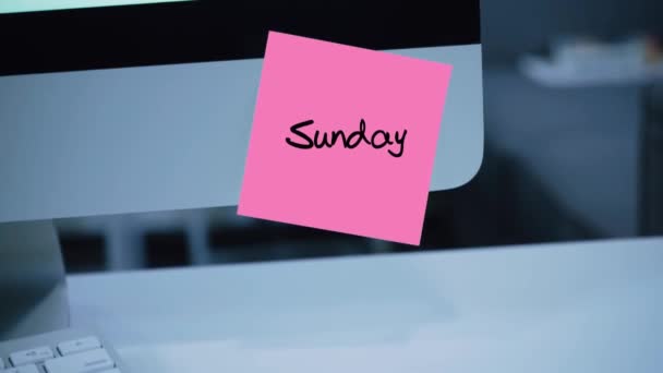 Sunday. Days of the week. The inscription on the sticker on the monitor. Message. Motivation. Reminder. Handwritten text written with a marker. Color sticker. A message for an employee, a colleague - Footage, Video