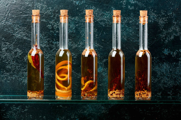 Bottles of olive oil with herbs and spices. - Фото, зображення