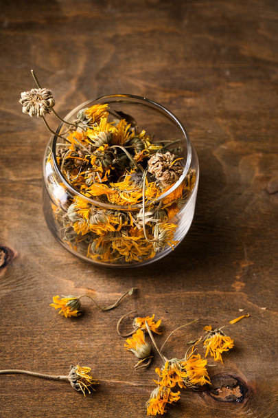 Dry calendula flowers in a glass jar, top view - Photo, Image
