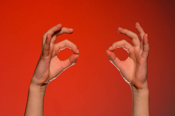 2 つの人間の手が、記号を表示 [ok] を赤の背景に分離 - 写真・画像