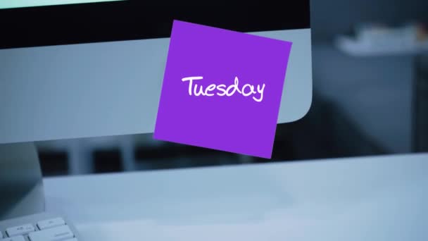 Tuesday. Days of the week. The inscription on the sticker on the monitor. Message. Motivation. Reminder. Handwritten text written with a marker. Color sticker. A message for an employee, a colleague - Footage, Video