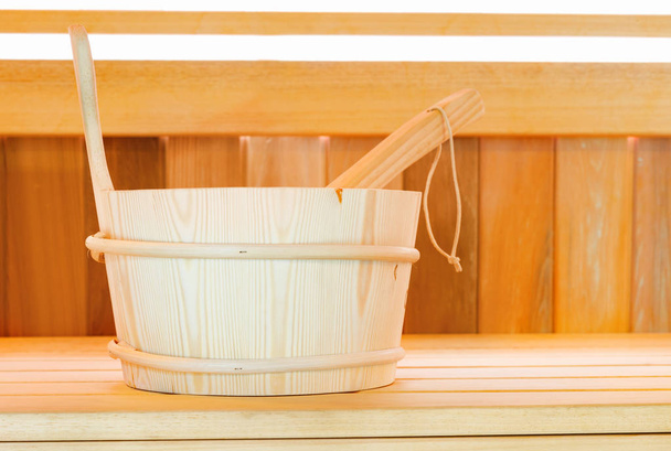 Традиционная финская деревянная сауна для отдыха с ведром воды и полотенцами
  - Фото, изображение