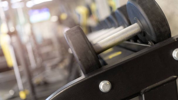 Rows of rubber dumbbells in the gym - 写真・画像