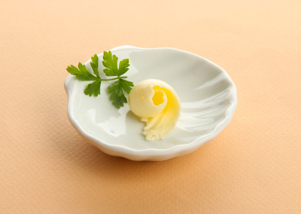 Butter curl on plate on beige background - Valokuva, kuva