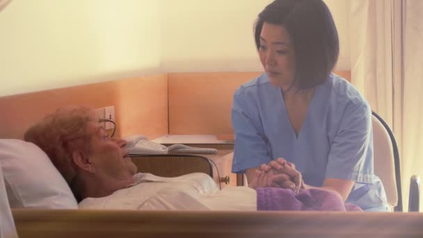 beeldmateriaal van verpleegster verzorgen van oudere vrouw in bejaardentehuis - Video