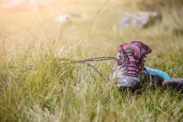Alpine boots are lying in the grass, hiking trip - Zdjęcie, obraz