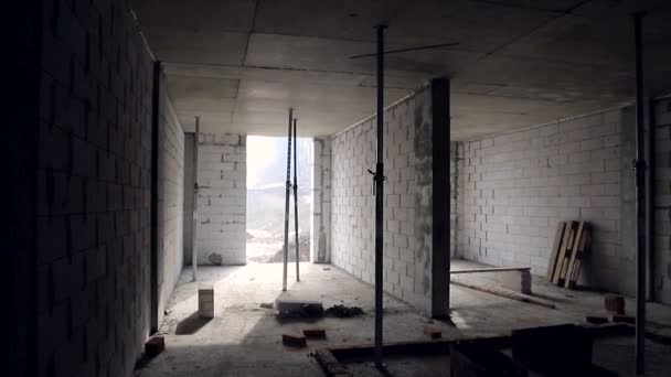 Wnętrze niedokończonego budynku pokoju. Budowa bloków gazowych i wewnętrznych przegród między pomieszczeniami - Materiał filmowy, wideo