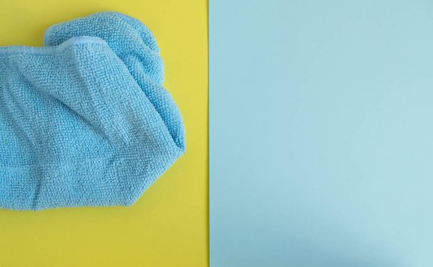 Microvezel doek op gele achtergrond, bovenaanzicht. Voorjaarsschoonmaak en huishoudconcept. Advertentieruimte met kopieerruimte, plat lay - Foto, afbeelding