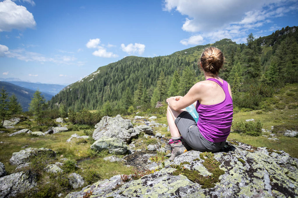 Nautitaan idyllinen vuoristo maisema: Tyttö istuu ro
 - Valokuva, kuva