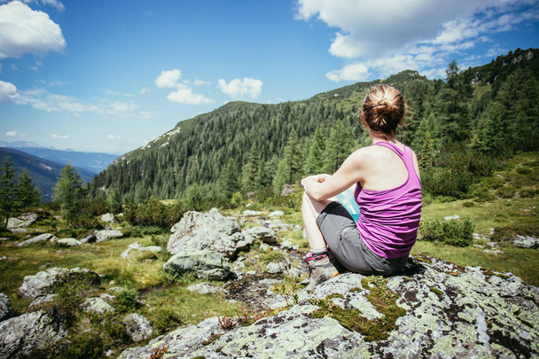 Élvezi a mi idilli hegyvidéki táj: lány ül a ro - Fotó, kép