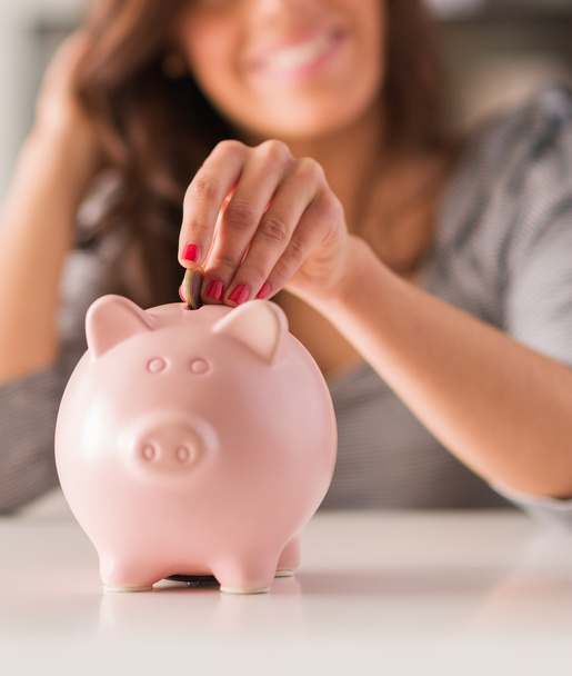 Woman Putting Coin In Piggy Bank - Photo, Image