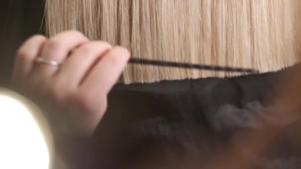 the hairdresser balances the golden hair tips - Footage, Video