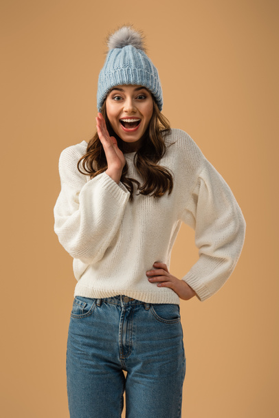 Excited brunette girl in white sweater laughing isolated on beige - Fotografie, Obrázek