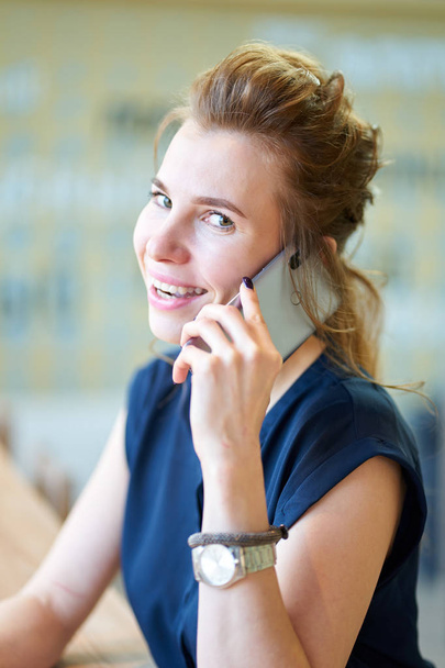 Jeune fille rousse maigre assis dans un café et parlant par téléphone
 - Photo, image